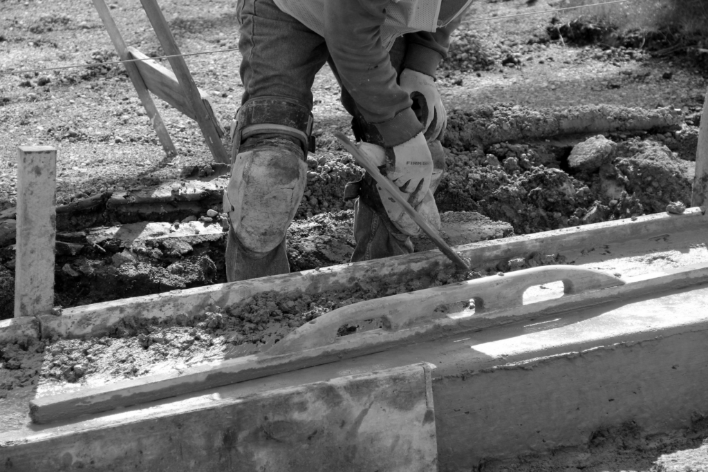 Construction labour worker finishing concrete on commercial jobsite