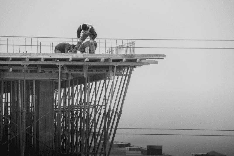 Construction workers installing steel reinforcement bars for concrete slab